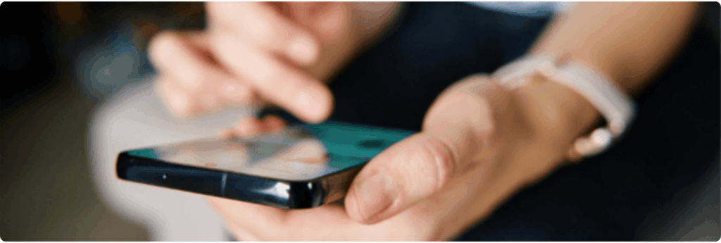 Close-up of a person using a smartphone, tapping the screen with one hand while holding it with the other, symbolizing digital engagement and connectivity. Ideal for promoting social media resilience training for local government.